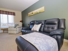 A living room with a black sofa and armchair at 27 Oversands View 