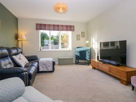 A living room with a sofa and television at 27 Oversands View