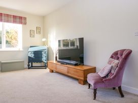 A living room with a sofa, table, and television at 27 Oversands View 