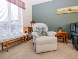 A living room with a recliner chair and a small table at 27 Oversands View