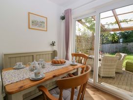 A dining room with a table set for tea and a view of a garden at 27 Oversands View 