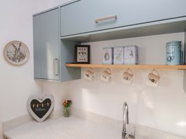 A kitchen with upper cabinets and a shelf holding canisters and mugs at 27 Oversands View