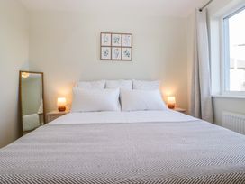 A bedroom with a bed, bedside table and mirror at 27 Oversands View 