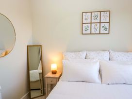 A bedroom with a bed and a bedside table at 27 Oversands View