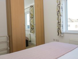 A bedroom with a bed and wardrobe at 27 Oversands View