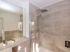 A bathroom featuring a shower, mirror, and sink at 27 Oversands View