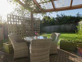 A garden with a seating area and trellis at 27 Oversands View
