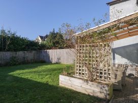 A garden with grass and a trellis at 27 Oversands View