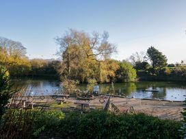 A view of a water body with benches and trees at 27 Oversands View