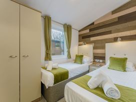 A bedroom with two beds and a wardrobe at Brayford Lodge (Pet) Louth