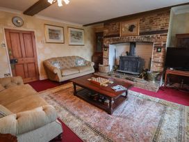 A living room with a fireplace and sofa at Farmhouse in Beccles