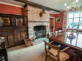 A dining room with a wooden table and fireplace at the Farmhouse in Beccles