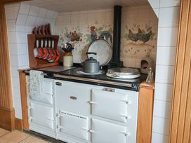 A kitchen with a stove and utensils at Farmhouse in Beccles