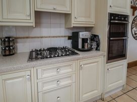 A kitchen with a stove and coffee maker at the Farmhouse in Beccles