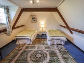 A bedroom with two beds and a lamp at the Farmhouse in Beccles