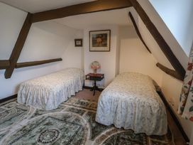 A bedroom with two beds and a lamp at Farmhouse in Beccles