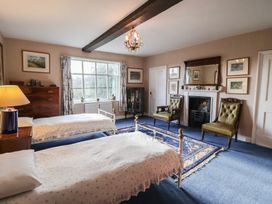 A bedroom with two beds and chairs at the Farmhouse in Beccles