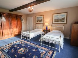 A bedroom with two beds and a wardrobe at Farmhouse in Beccles