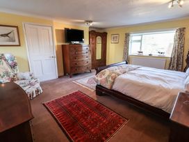 A bedroom with a bed, wardrobe, and television at the Farmhouse in Beccles