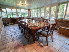 A dining room with a long table and chairs at Farmhouse in Beccles