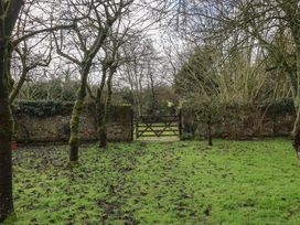 A garden with trees and a gate at Farmhouse in Beccles