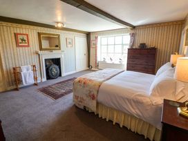 A bedroom with a bed and dresser at Winston Hall in Beccles