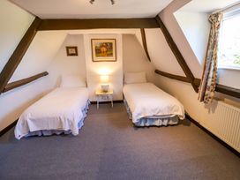 A bedroom with two single beds and a lamp at Winston Hall in Beccles