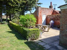 A garden with a patio table and grill at Winston Hall in Beccles