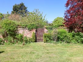 A garden with a wooden gate and greenery at Winston Hall in Beccles
