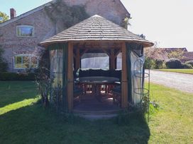A gazebo with seating in a garden at Winston Hall in Beccles