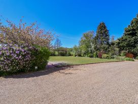 A garden with flowering bushes and a lawn at Winston Hall in Beccles