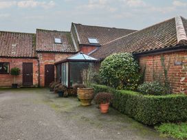 An outdoor area with a conservatory and hedges at Winston Lodge in Beccles