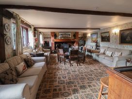A living room with a sofa and dining table at Winston Lodge in Beccles