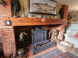 A living room with a brick fireplace and decorative features at Winston Lodge in Beccles