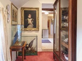 A hallway with a painting and display cabinet at Winston Lodge in Beccles