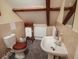 A bathroom with a toilet, sink, and towel rack at Winston Lodge in Beccles