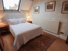 A bedroom with a bed and lamp at Winston Lodge in Beccles