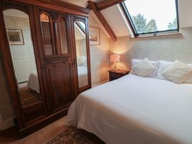 A bedroom with a bed and wardrobe at Winston Lodge in Beccles