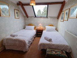 A bedroom with two single beds and a nightstand at Winston Lodge in Beccles