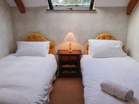 A bedroom with two single beds and a nightstand at Winston Lodge in Beccles
