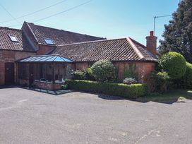 A house with a conservatory and garden at Winston Lodge in Beccles