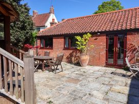 An outdoor patio with a table and chairs at Winston Lodge in Beccles