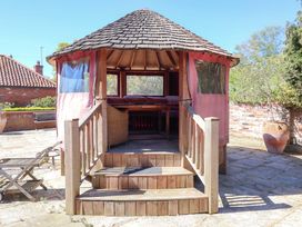 A gazebo with seating and table in an outdoor area at Winston Lodge in Beccles