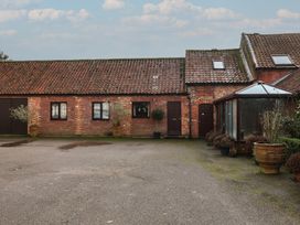 An outdoor view of a brick building with potted plants at The Gun Room in Beccles