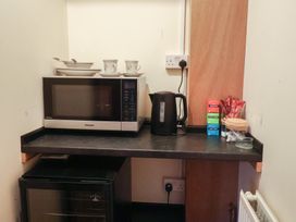 A kitchen corner with microwave kettle and cups at The Gun Room in Beccles