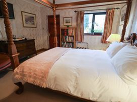 A bedroom with a bed, lamp, and bookshelf at The Gun Room in Beccles