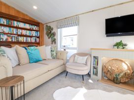 A living room with a sofa and bookshelf at FW4 (Fairways 4)