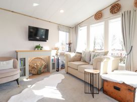 A living room with a television, sofa, and windows at FW4 (Fairways 4)