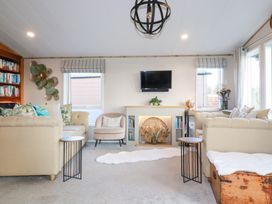 A living room with a sofa and bookshelves at FW4 (Fairways 4)