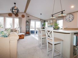 A living room with a sofa, dining chairs, and a clock at FW4 (Fairways 4)